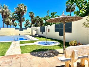 un patio con banco y sombrilla en Apartamentos Boutique Terrazas, en Oropesa del Mar