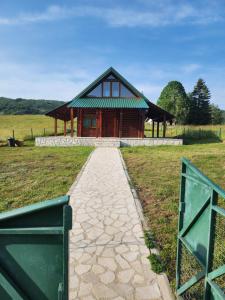 a building with a pathway in front of it at Planinska tišina Guest House in Pluzine