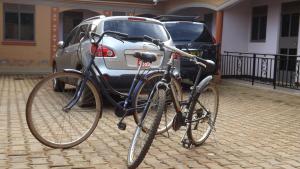 een fiets geparkeerd voor een auto bij Antique Apartments in Entebbe