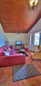 a large living room with a large red couch at Villa Catanho in Funchal