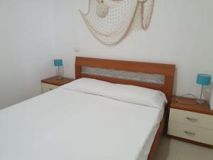 1 dormitorio con 1 cama y mesita de noche con 2 lámparas en Casa Vacanze Il Giardino Dei Girasoli, en Marina di Ragusa
