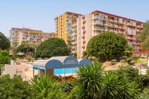 a resort with a swimming pool and a building at Apartamento vistas a piscina in Benalmádena