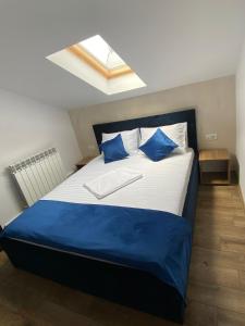a bedroom with a large bed with blue pillows at Casa Marisa in Eforie Nord