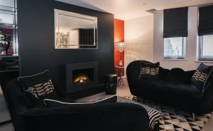 a living room with two black couches and a fireplace at Square Townhouse in Brighton & Hove