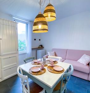jadalnia ze stołem i różową kanapą w obiekcie Locanda alla Grotta w mieście Crone