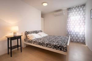 a small bedroom with a bed and a window at Villa Ivka - 100 m do plaže uvala Soline - KRK in Malinska +24 photos