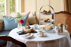 una mesa con un plato de pasteles y postres. en Penmaenuchaf Hotel, en Dolgellau