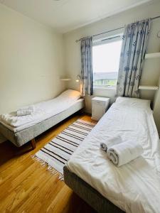 two beds in a room with a window at Ramberg Gjestegård in Ramberg