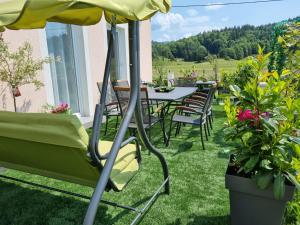 eine Terrasse mit einem Tisch, Stühlen und einem Sonnenschirm in der Unterkunft Villa Lady Di Plitvice in Vrhovine