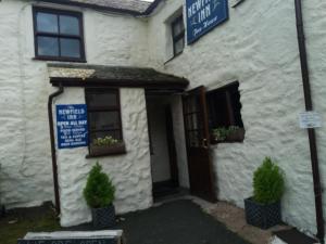 un edificio bianco con un cartello davanti di NEWFIELD INN a Broughton-in-Furness