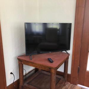 een televisie op een houten tafel met afstandsbediening bij Seabreeze Three Bedroom Home in Rochester