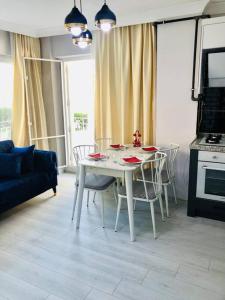 einen weißen Tisch und Stühle im Wohnzimmer in der Unterkunft Sea View Modern Appartement with a Privet Garden in Çiftlikköy
