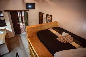 1 dormitorio con cama de madera en una habitación en Hotel Molino del Cerrillo en San Cristóbal de Las Casas