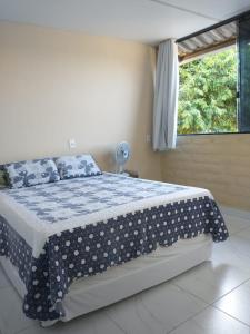 a bedroom with a bed with a blue and white comforter at Casa refúgio in Cavalcante
