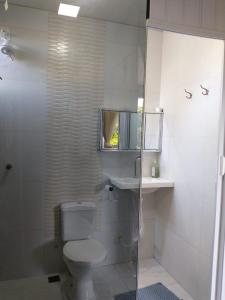 a bathroom with a toilet and a glass shower at Casa refúgio in Cavalcante
