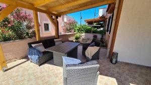a patio with couches and a table and chairs at Kitty in Povljana
