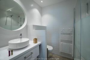La salle de bains blanche est pourvue d'un lavabo et d'un miroir. dans l'établissement Appt Standing Terrasse Vue d'exception - la Mongie, à Bagnères-de-Bigorre