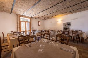 Cuore Nero Food and Relax في سانتو ستيفانو دي سيسانيو: مطعم فيه طاولات وكراسي في الغرفة