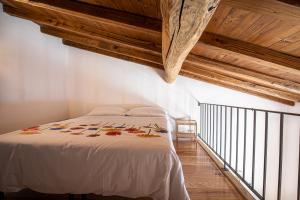 a bedroom with a white bed with wooden ceilings at Cuore Nero Food and Relax in Santo Stefano di Sessanio