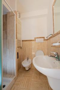 a bathroom with a sink and a toilet and a tub at Cuore Nero Food and Relax in Santo Stefano di Sessanio