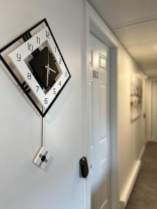 a clock hanging on a wall next to a door at Le Chambreur in Rouyn