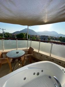 a bath tub sitting on a balcony with a table at Tulip Apart Hotel in Ortaca