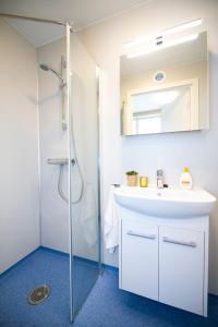 ein Badezimmer mit einem weißen Waschbecken und einer Dusche in der Unterkunft Sjøholt Sommerhotell in Ørskog