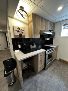 a kitchen with a counter and a sink and a stove at Le Chambreur in Rouyn-Noranda +28 photos