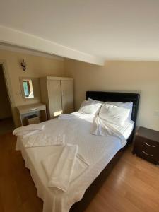 a bedroom with a large bed with white sheets and pillows at Tulip Apart Hotel in Ortaca