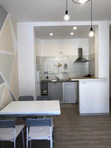 eine Küche mit einem Tisch und Stühlen im Zimmer in der Unterkunft appartmentslapiazzetta-n.3 in Sesto Calende