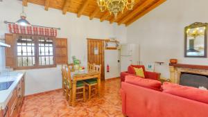una cucina e un soggiorno con divano rosso e tavolo di La PacAna Álora by Ruralidays ad Alora