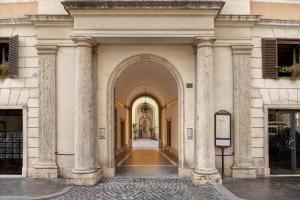 ローマにあるBorghese Contemporary Hotelの柱の建つ建物のアーチ道