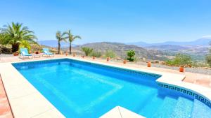 una piscina in una villa con montagne sullo sfondo di La PacAna Álora by Ruralidays ad Alora