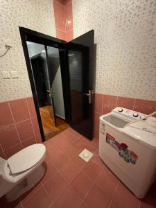 a bathroom with a toilet and a washing machine at غرفتين نوم ومجلس في ابها بالقرب من Lavanda Park in Abha