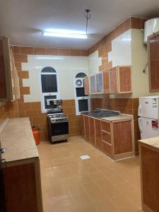 a large kitchen with wooden cabinets and appliances at غرفتين نوم ومجلس في ابها بالقرب من Lavanda Park in Abha +4 photos