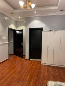 an empty room with white cabinets and black doors at غرفتين نوم ومجلس في ابها بالقرب من Lavanda Park in Abha