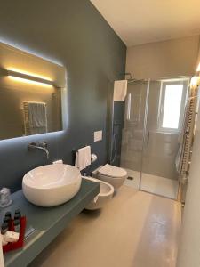a bathroom with two toilets and a sink and a shower at Sant'Elia Deluxe Rooms in Vieste