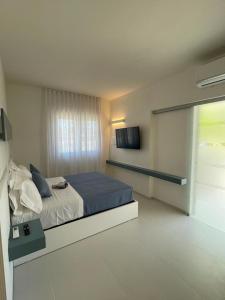 a bedroom with a bed and a television in it at Sant'Elia Deluxe Rooms in Vieste +14 photos