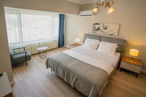 Verula City Apartments في طرابزون: غرفة نوم بسرير وكرسي ونافذة