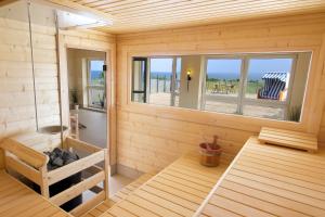 a wooden room with a bench and a window at Bootsmann 08 in Schashagen