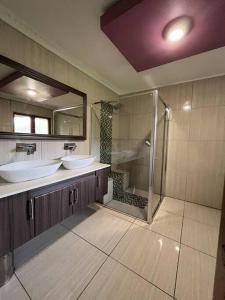 a large bathroom with two sinks and a shower at Rifumo Luxury Villa in Kruger Park Lodge in Hazyview