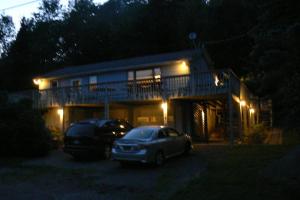 ein Haus mit zwei Autos, die nachts davor geparkt sind in der Unterkunft Catskill Mountain Retreat in West Kill