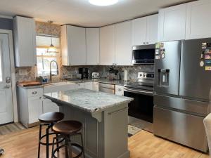a kitchen with white cabinets and stainless steel appliances at Catskill Mountain Retreat in West Kill