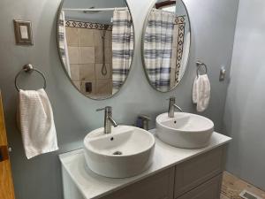 ein Badezimmer mit zwei Waschbecken und zwei Spiegeln in der Unterkunft Catskill Mountain Retreat in West Kill