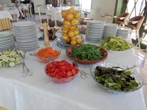 uma mesa com tigelas de legumes e pratos em Hotel Termas da Curia em Curia