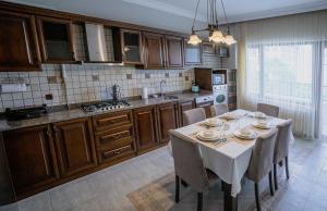 uma cozinha com uma mesa com cadeiras e uma toalha de mesa branca em Verula City Apartments em Trebizonda
