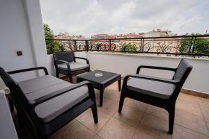 Verula City Apartments في طرابزون: ثلاثة كراسي وطاولة على شرفة مطلة