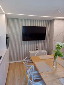 Sumowo的住宿－Apartament z kominkiem，一间设有桌子和墙上电视的用餐室