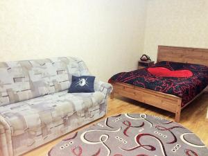 a living room with a couch and a bed and a rug at Apartment on Malysheva 84-5 in Yekaterinburg