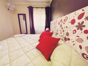 a bedroom with a large bed with red pillows at Fonda Aparicio in Fuentespalda